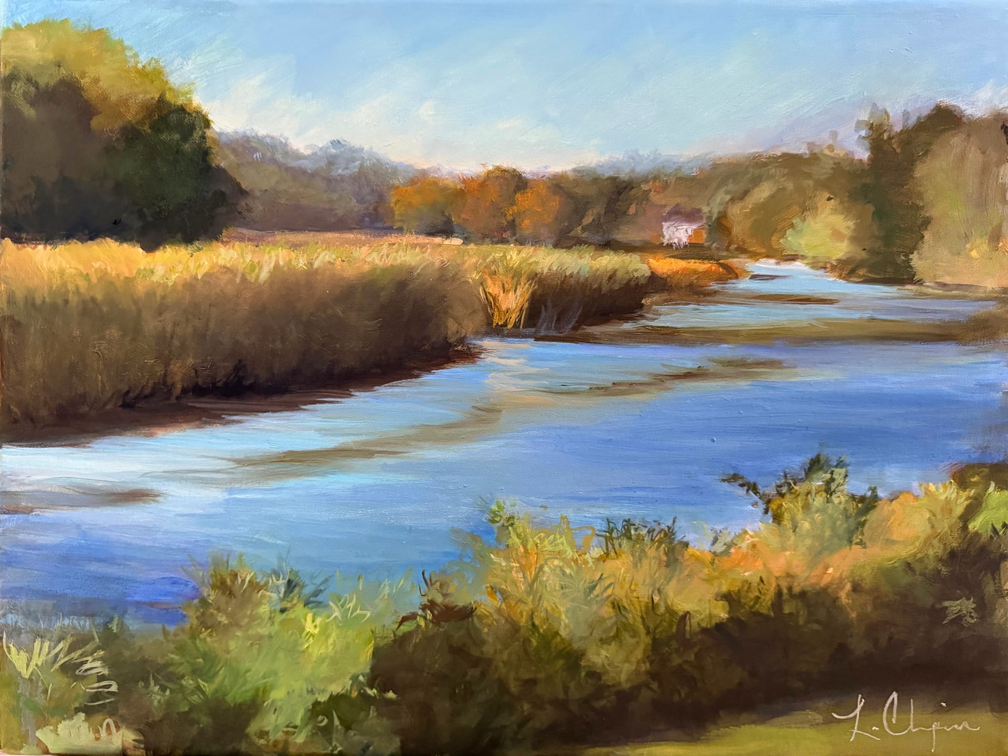 A tidal river winding between banks of gold marsh grass toward a distant treeline turning red and gold, under a pale blue sky. Oil painting by Lorraine Skelskey-Chapin, 12 by 16 inches.
